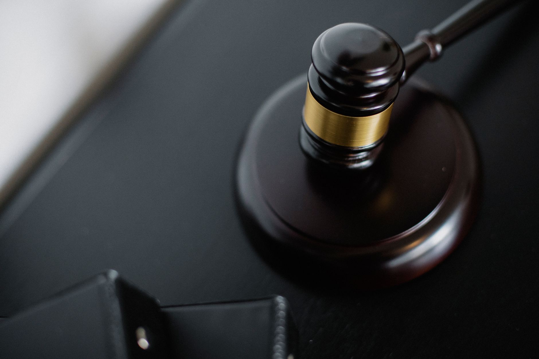 From above of wooden gavel on round surface near folders on table