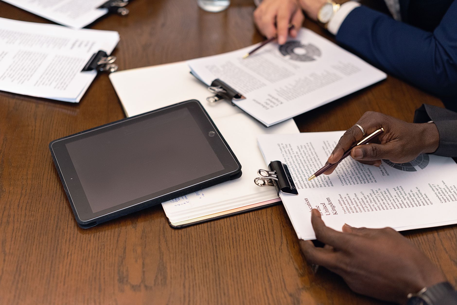 A business meeting with tablets and documents, showcasing digital integration in a
