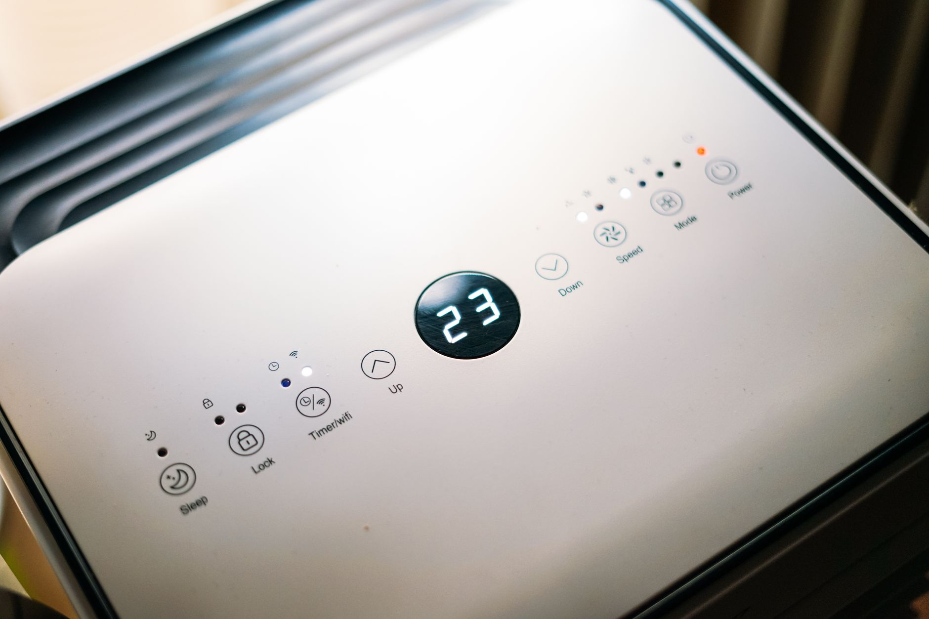 Close-up of a sleek air conditioner control panel displaying temperature.