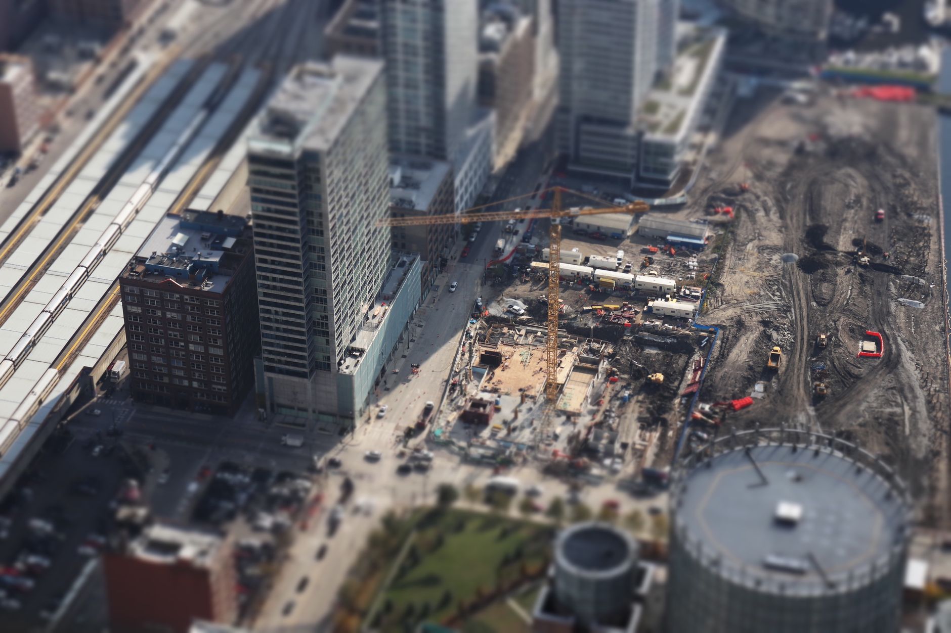 An aerial tilt-shift view of a bustling construction site in downtown Chicago,