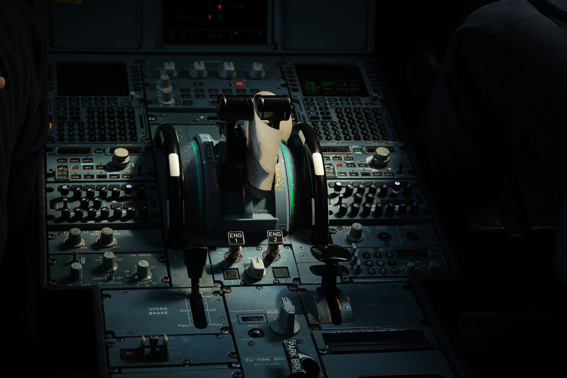 Detailed view of airplane cockpit control panel with levers and switches.