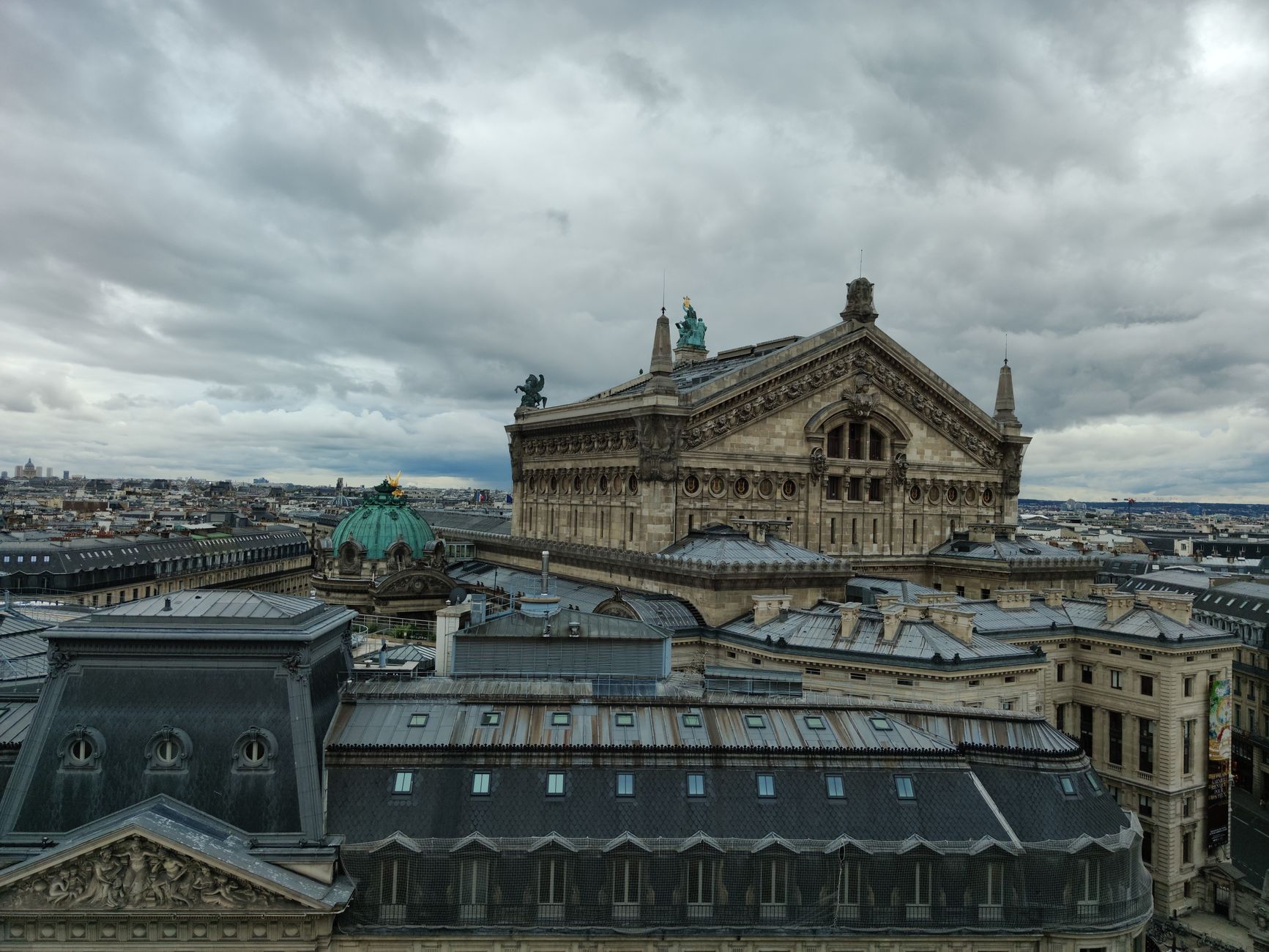Stunning aerial shot of Palais Garnier under a cloudy sky, showcasing classic