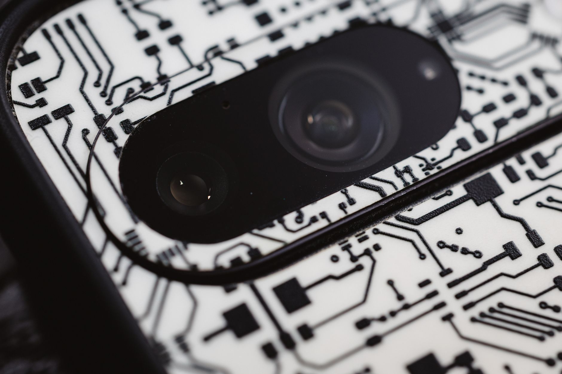 Macro shot of an electronic circuit design around a smartphone camera lens,
