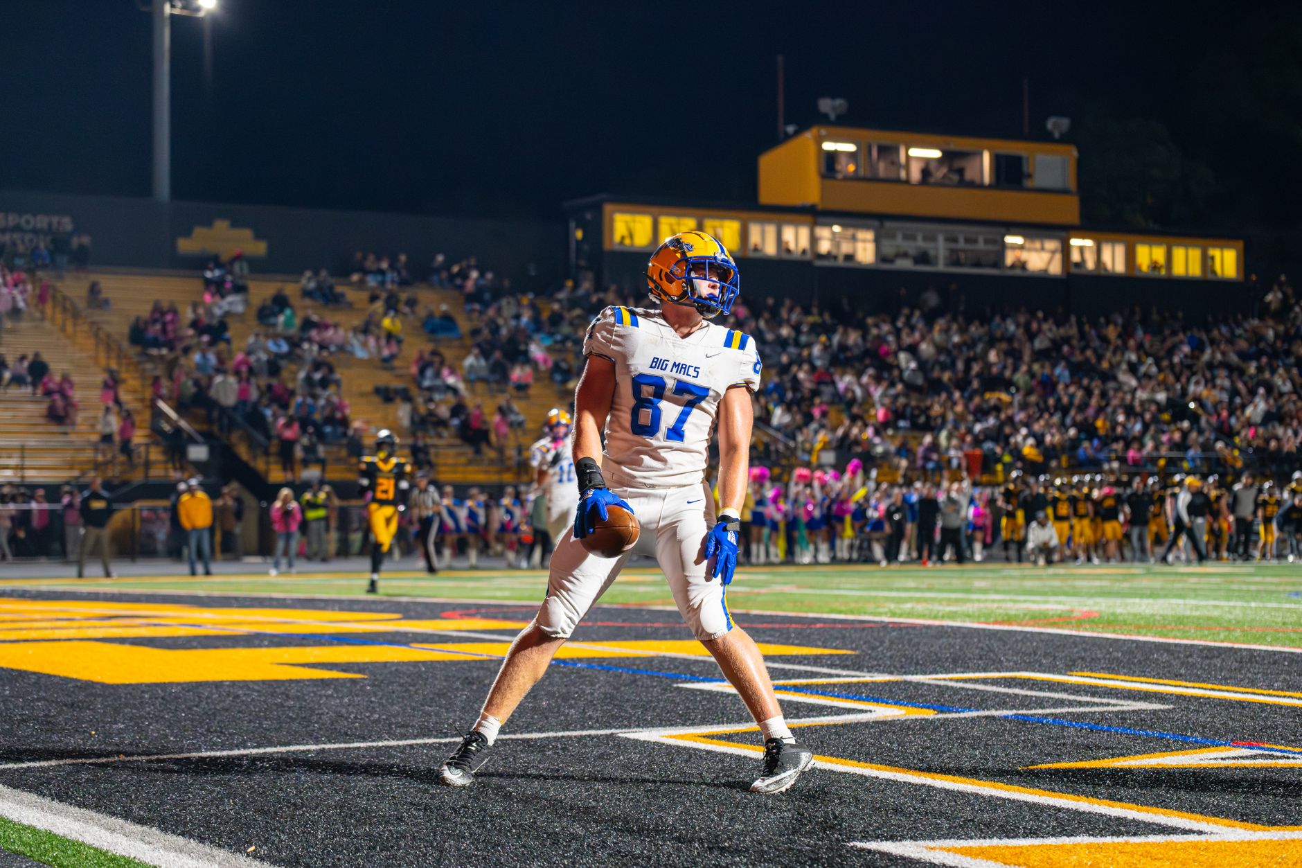 An excited football player celebrates a touchdown during a thrilling night game