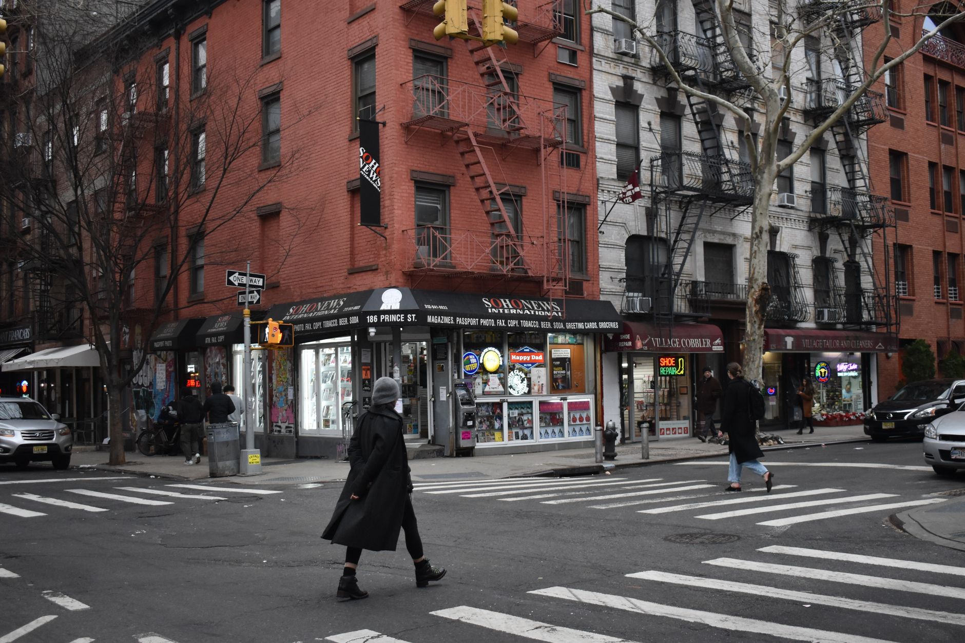 Pedestrians crossing a street at an intersection in Brooklyn, NYC with shops