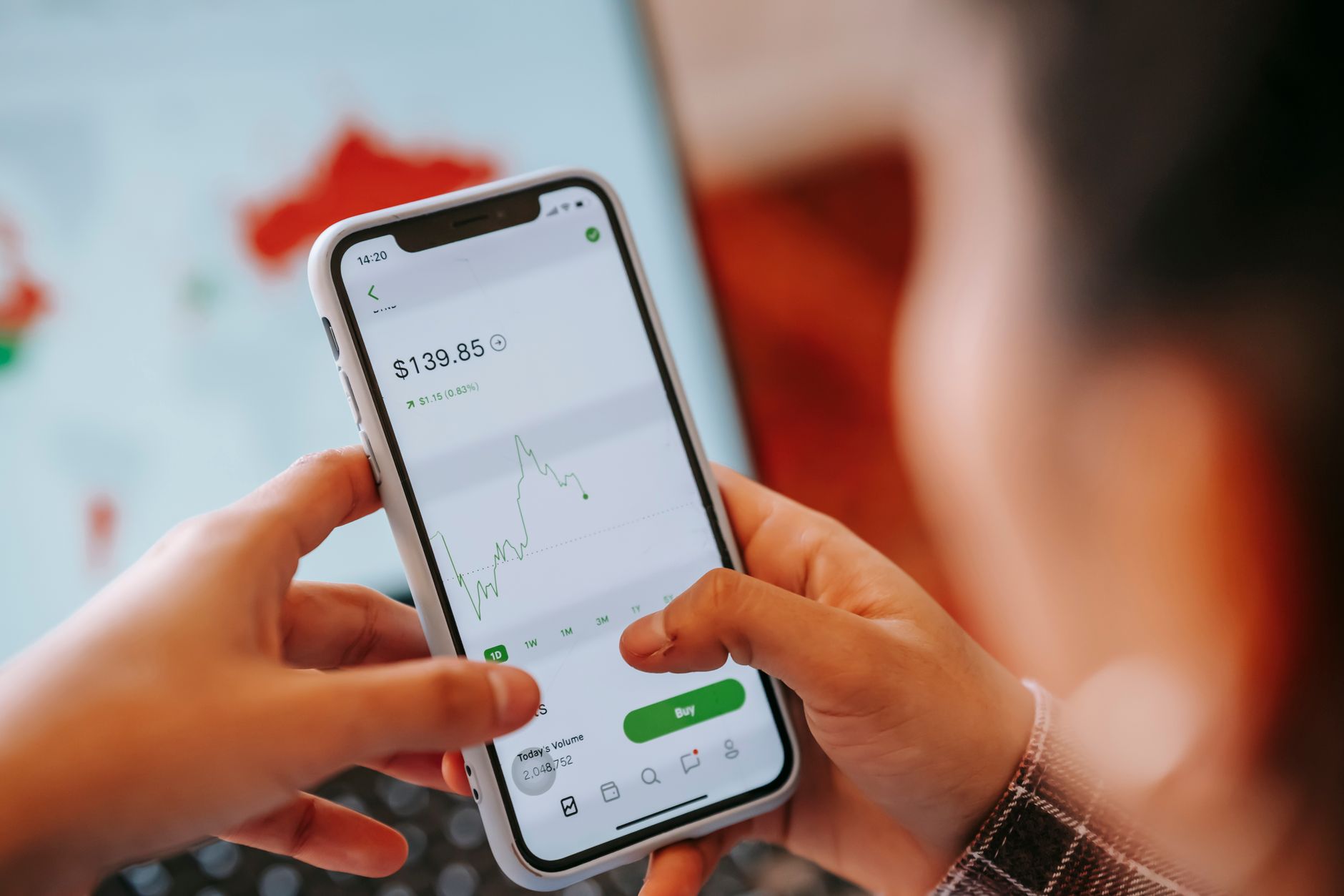 Crop anonymous trader using app on cellphone with graph and dollar price