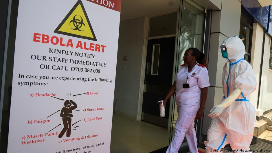 Health workers and officials walk outside a Ebola isolation facility at The Nairobi Hospital, Kenya