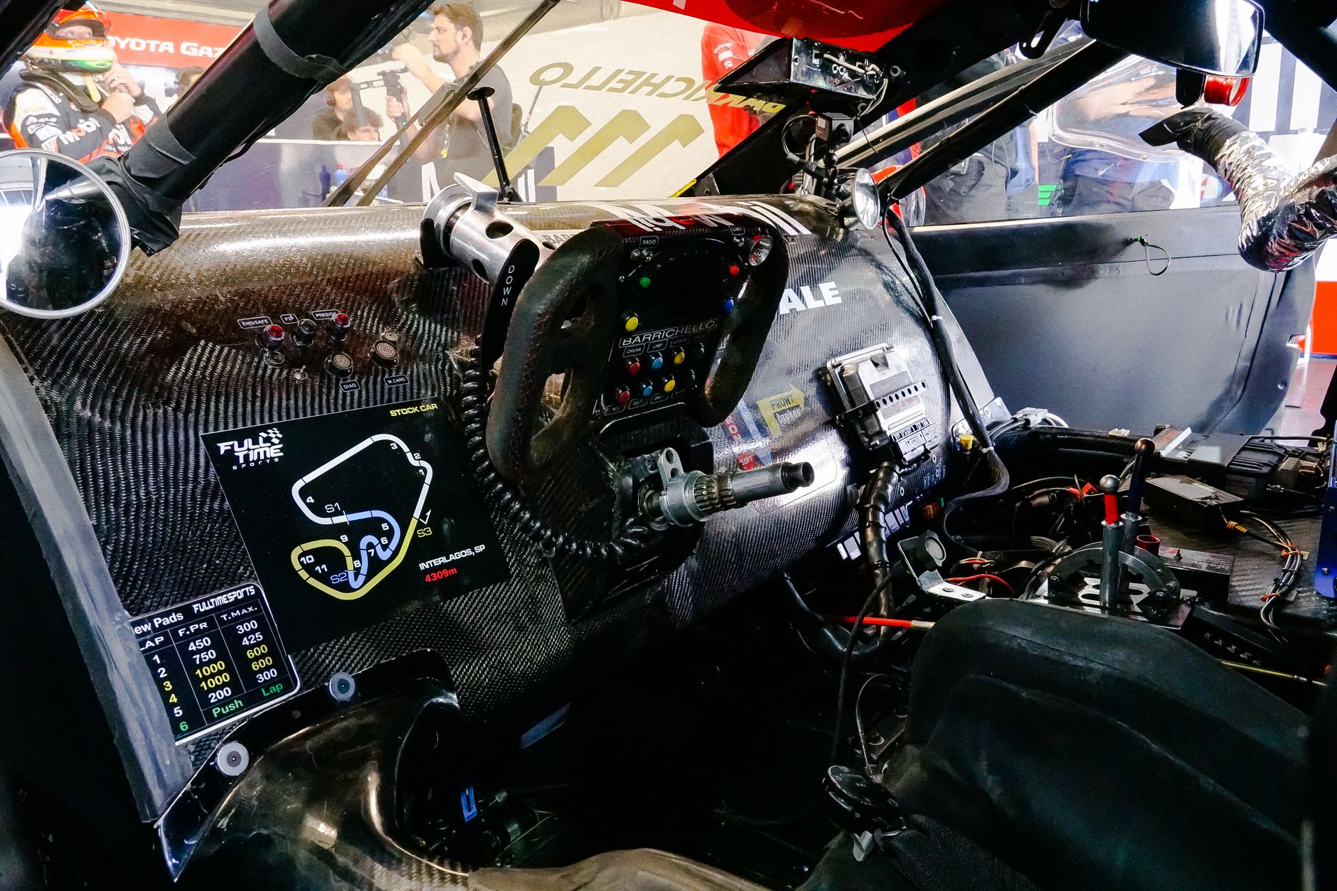 Detailed view of a racing car's cockpit highlighting the carbon fiber dashboard