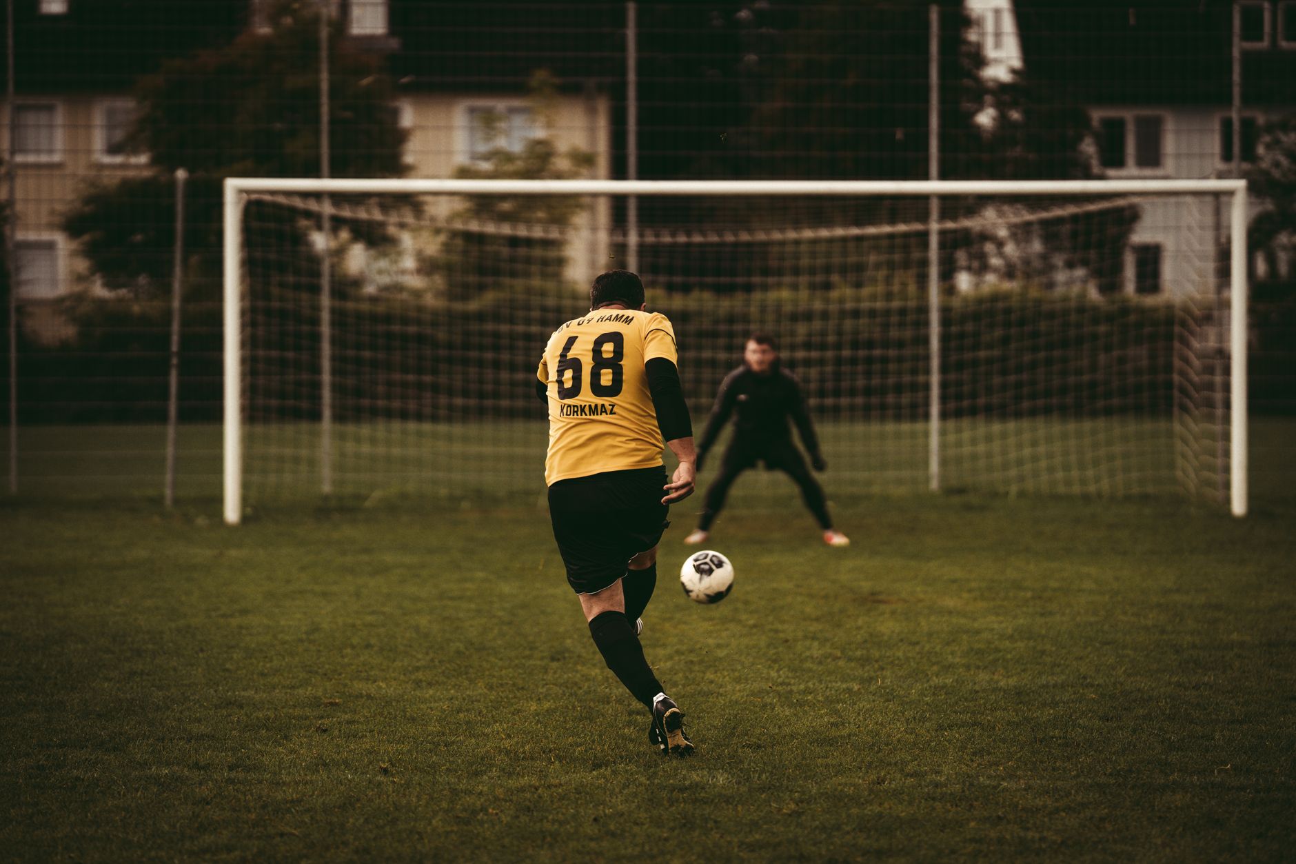 A soccer player takes a decisive penalty kick aiming to score against