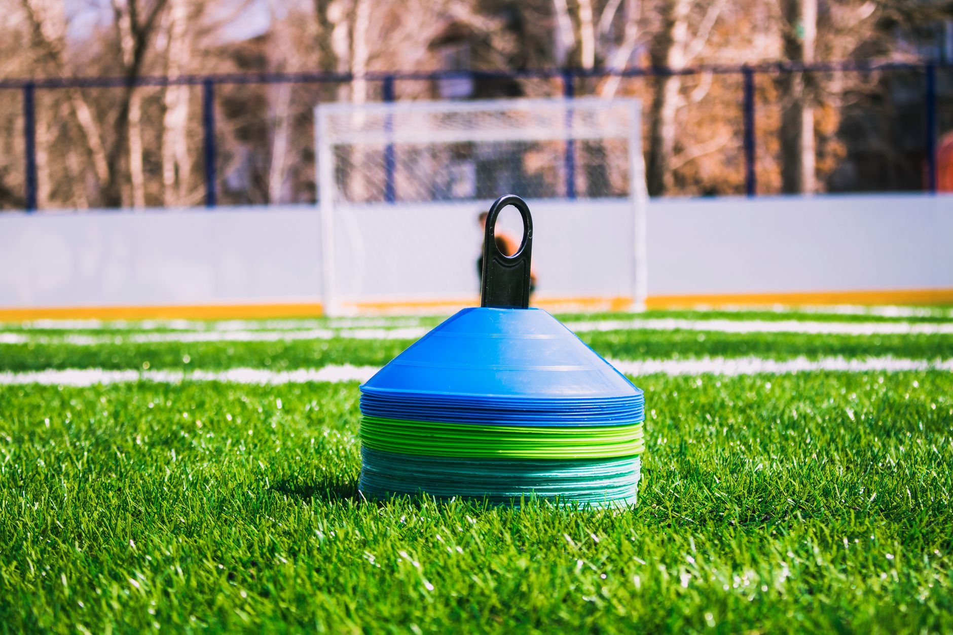 Colorful training cones on an outdoor soccer field with goal in the