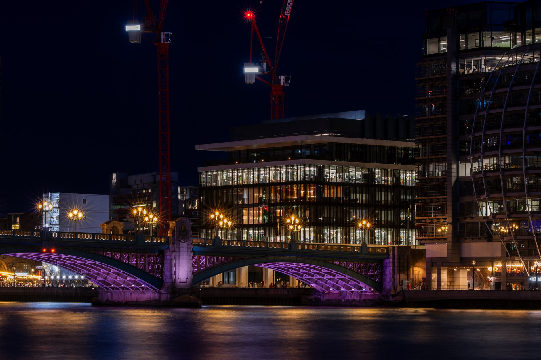 Captivating view of illuminated modern buildings and bridge along the River Thames