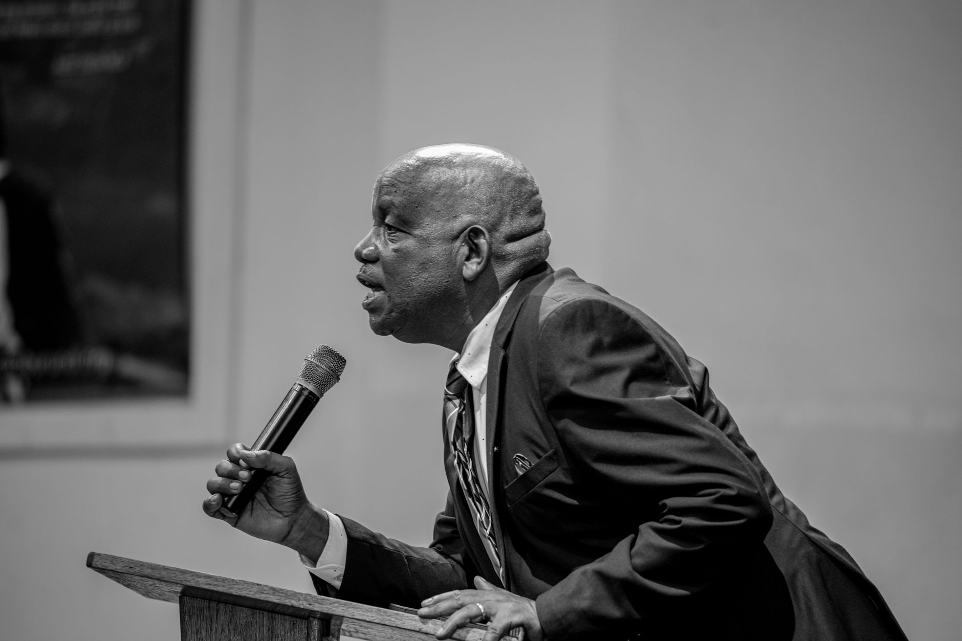 Black and white photo of a speaker at a podium with a