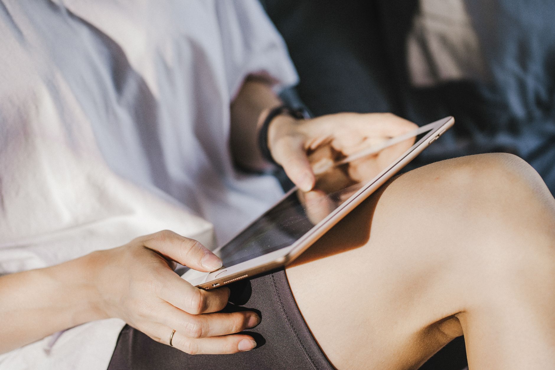 A person holding and using a digital tablet, depicted in a close-up