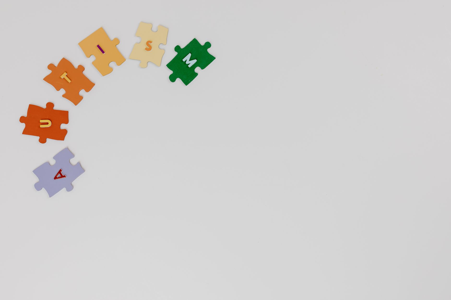 Puzzle pieces spelling autism on a white background, symbolizing autism awareness.