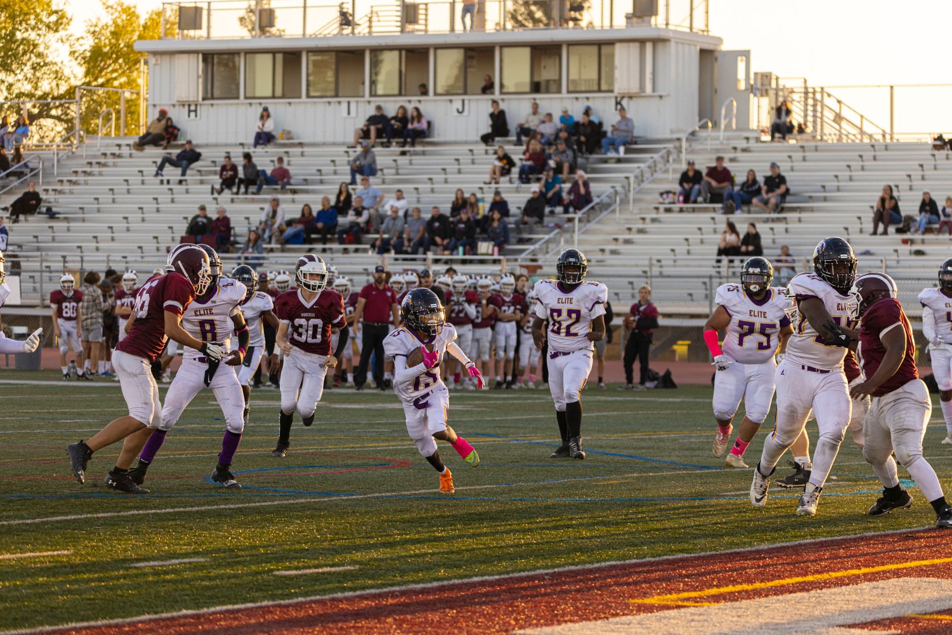 Intense American football game with players in action at a bustling stadium,