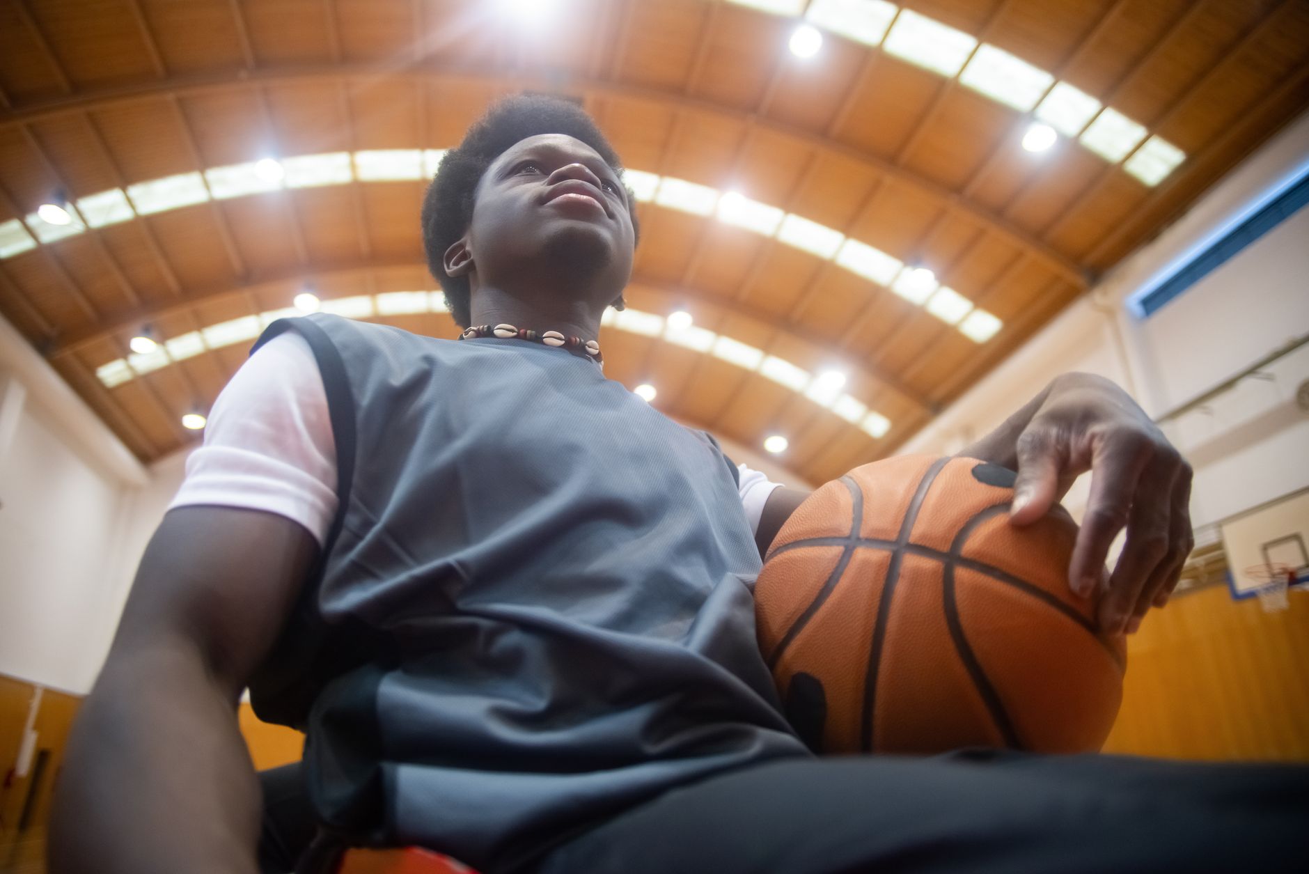 Low-angle shot of a basketball player holding a ball in an indoor