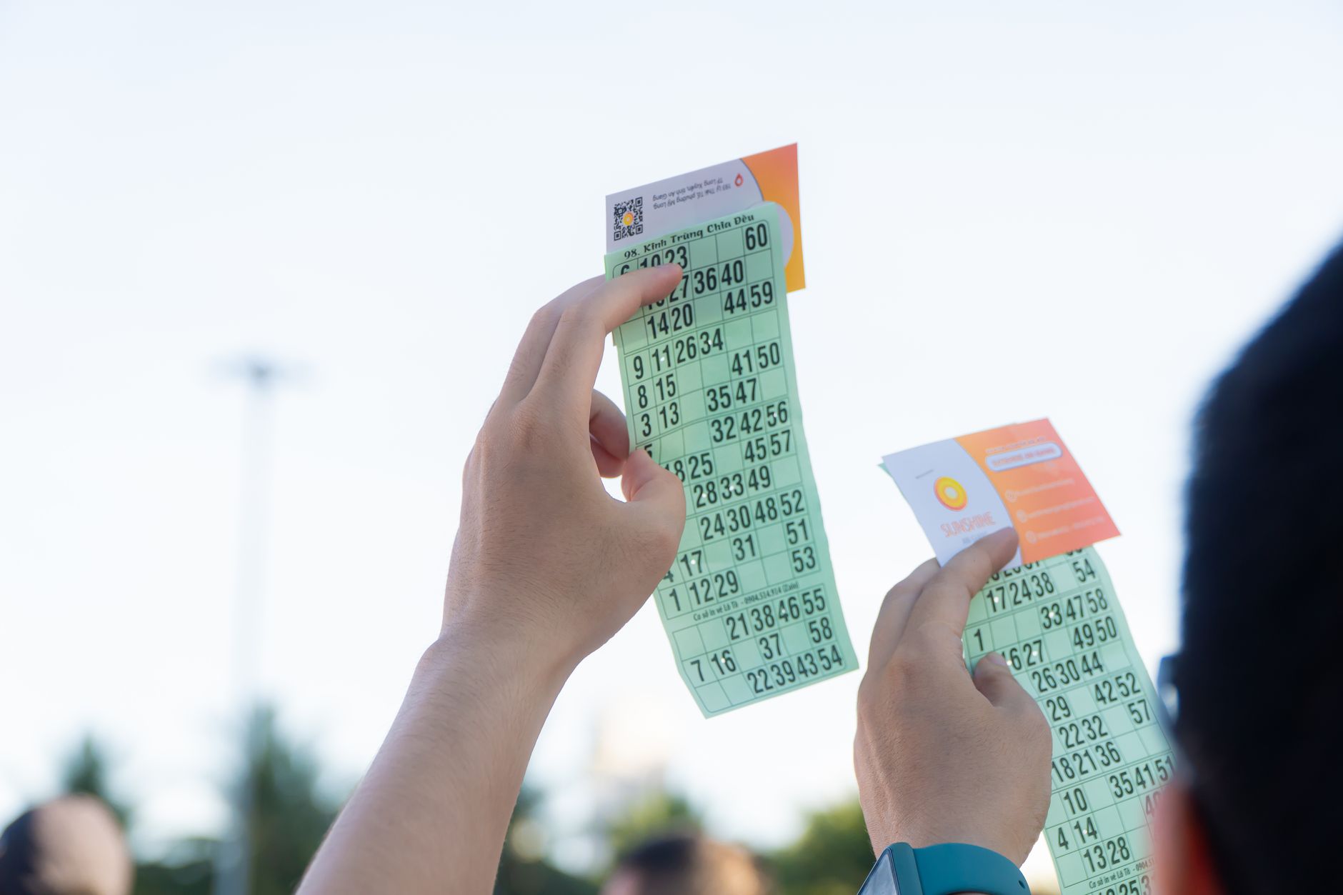 Close-up of hands holding transportation tickets, showcasing numbers and fare details.