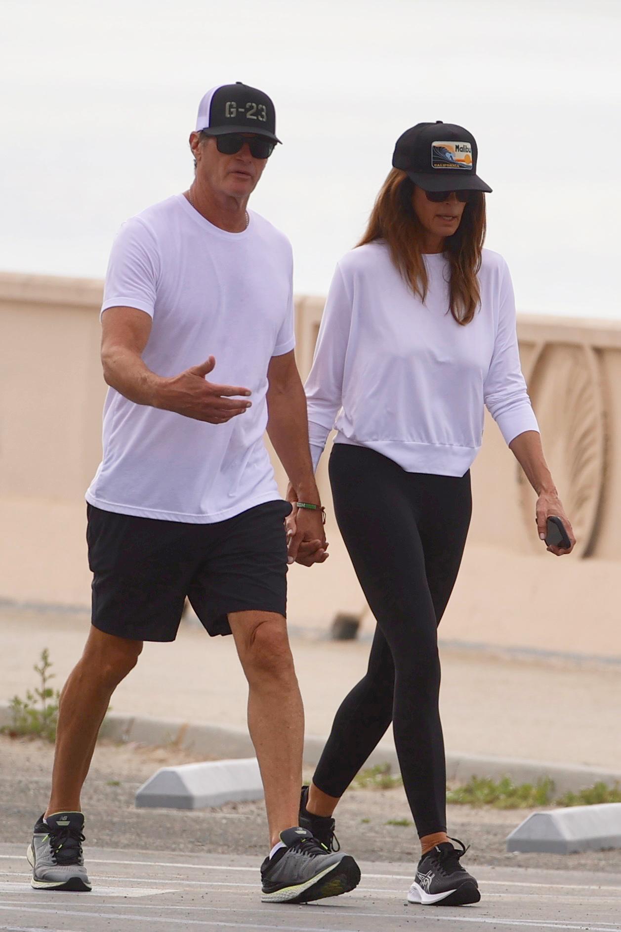 Cindy Crawford and Rande Gerber walking together hand-in-hand at Zuma Beach.