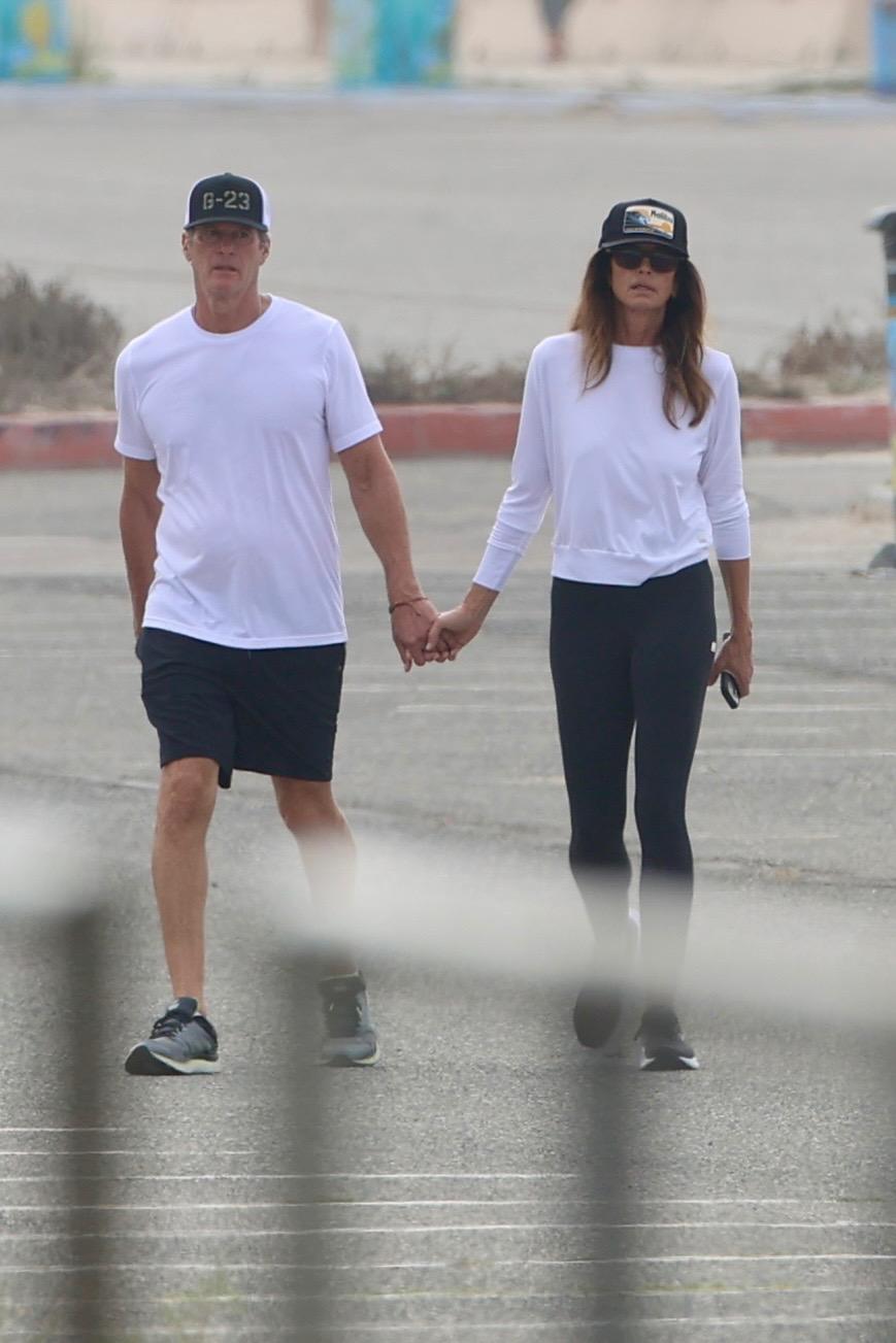 Cindy Crawford and Rande Gerber walk together hand-in-hand at Zuma Beach in Malibu.