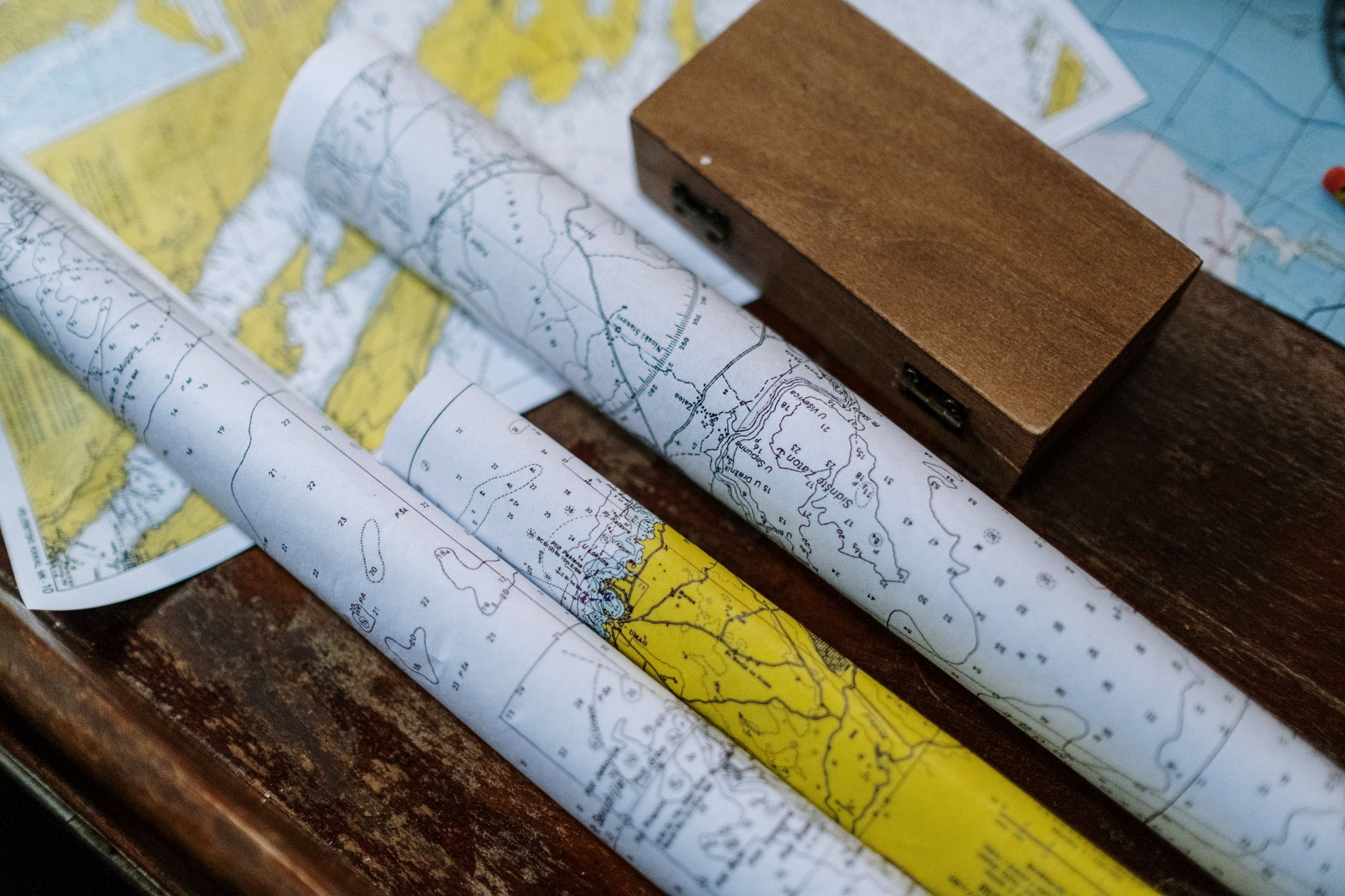 Close-up of rolled nautical maps on a wooden table, perfect for navigation