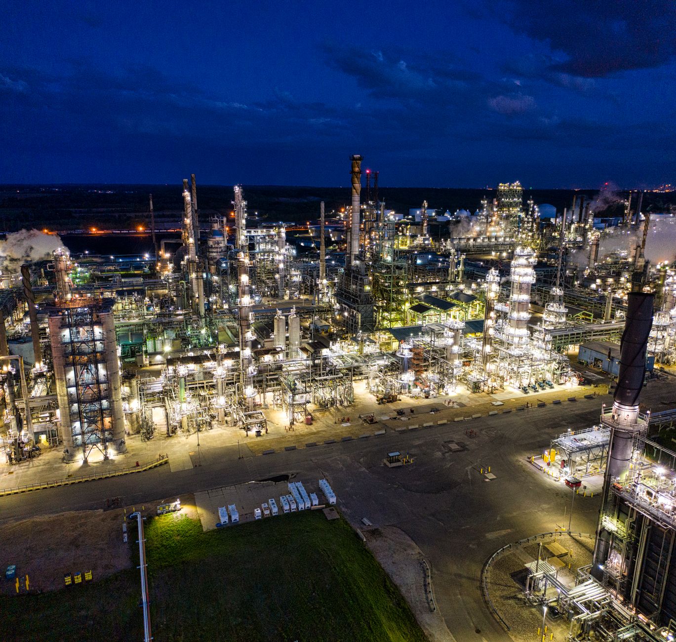 Dramatic aerial shot of an illuminated oil refinery at night in Rosemount,