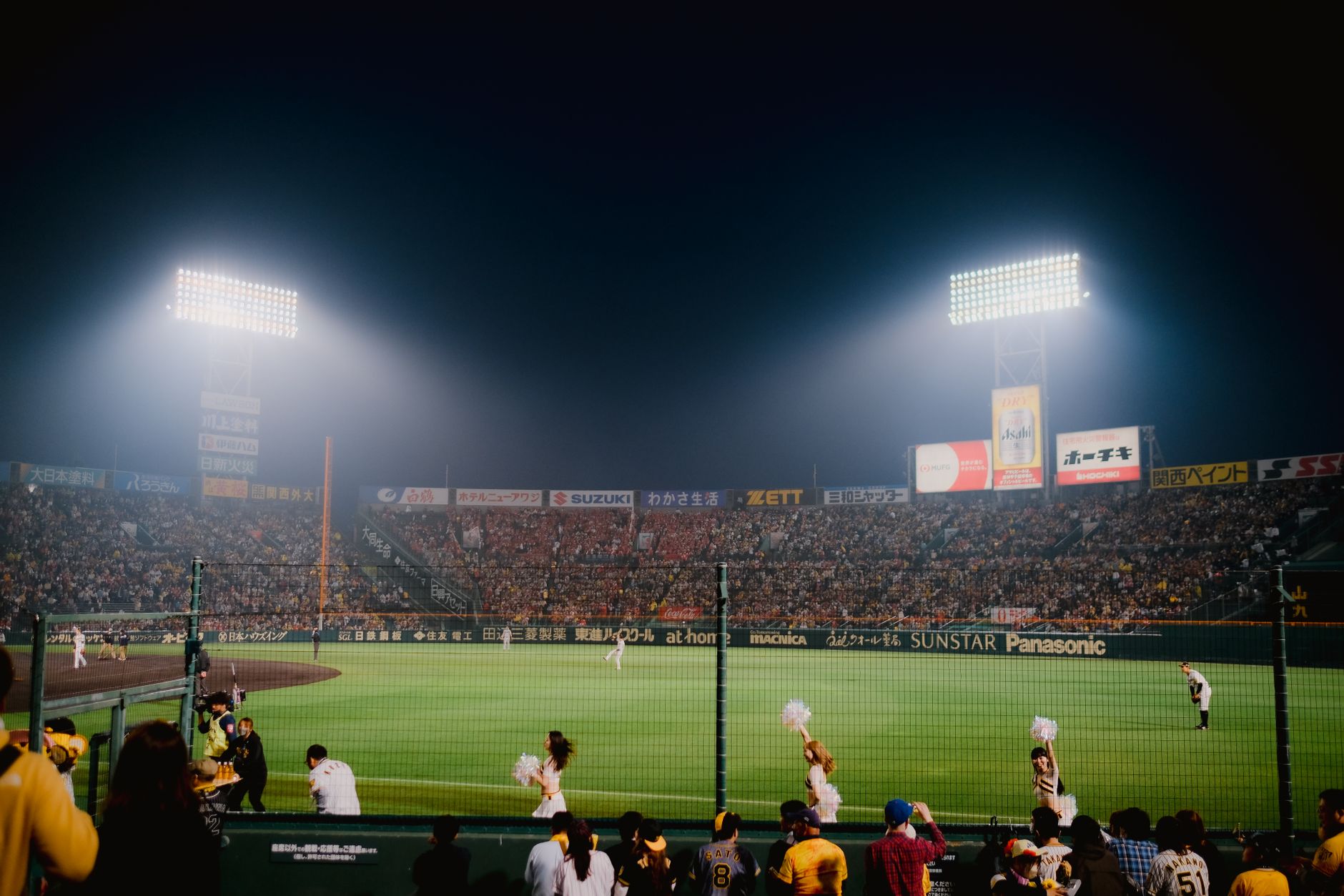 Thrilling night baseball game at Hanshin Koshien Stadium in Japan with vibrant