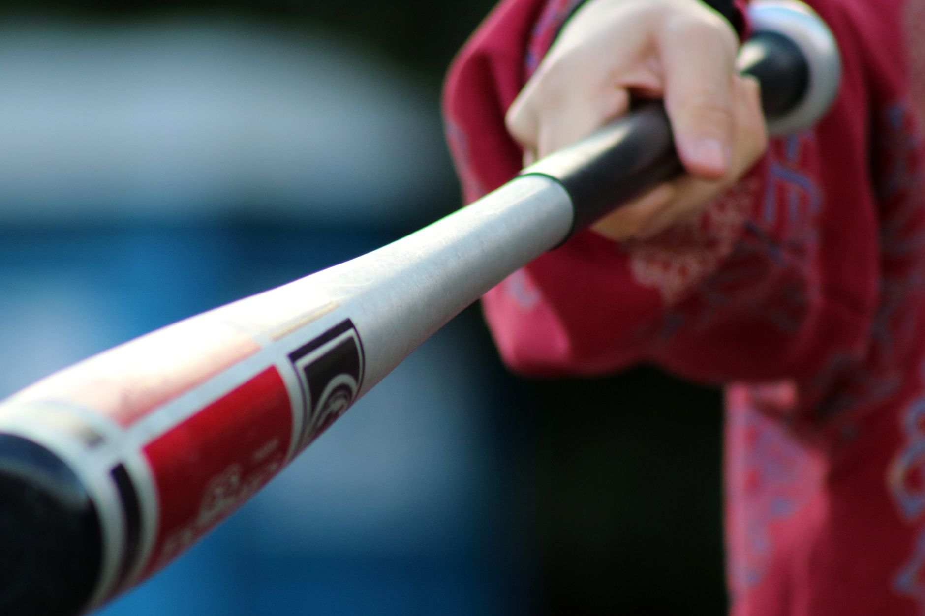 Close-up shot of a hand gripping a baseball bat, showcasing action and