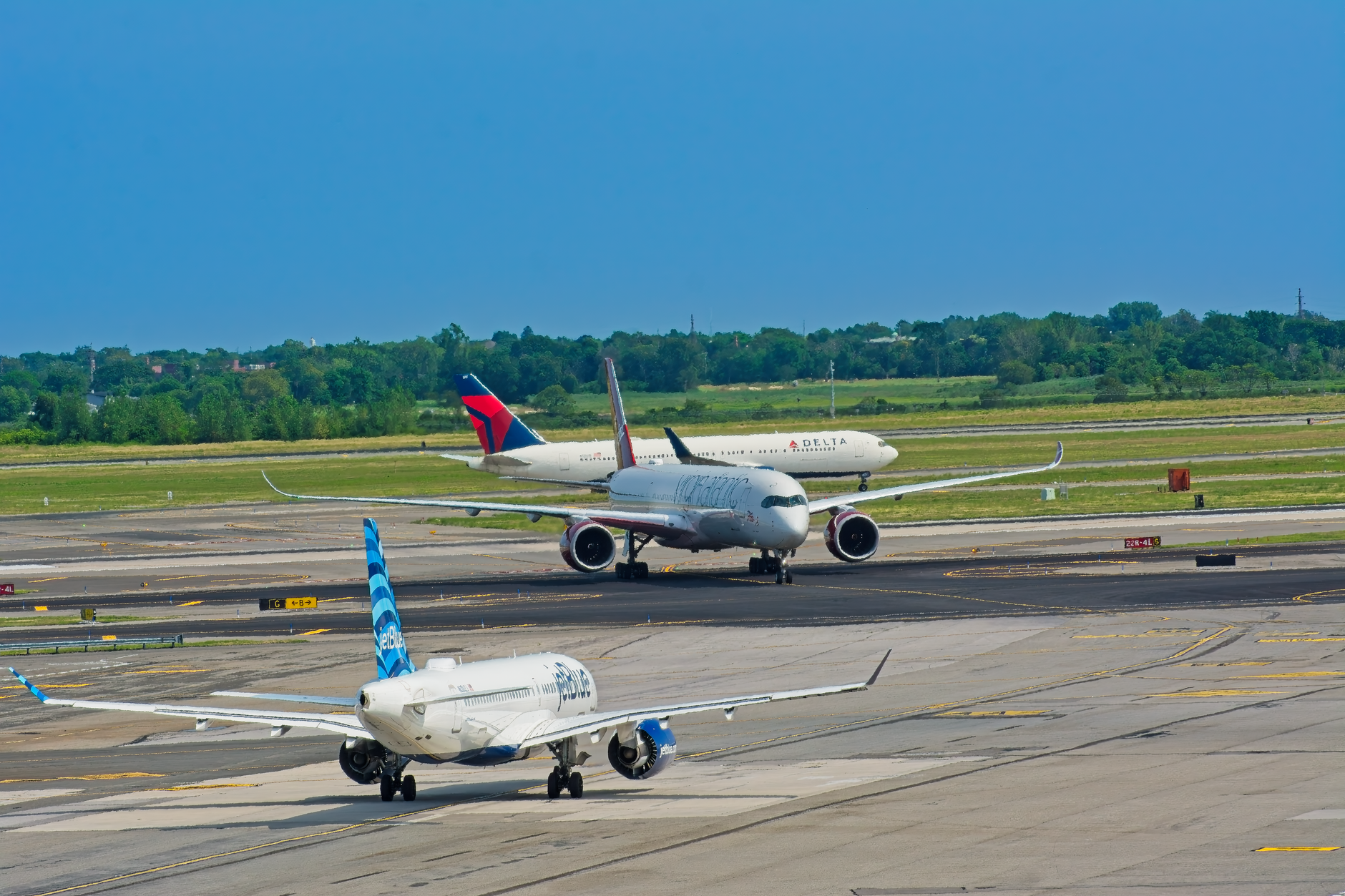 Airplanes from various airlines taxiing on a JFK airport runway in New