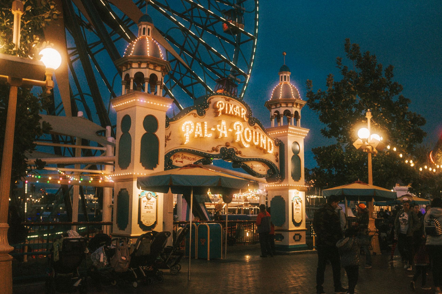 The iconic entrance of the Pixar Pal-A-Round ferris wheel illuminated at night