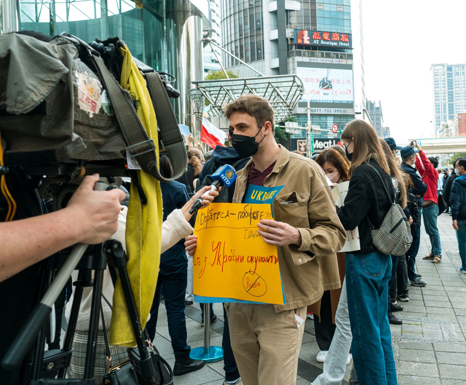 Young man holds protest sign during street demonstration against war, covered by