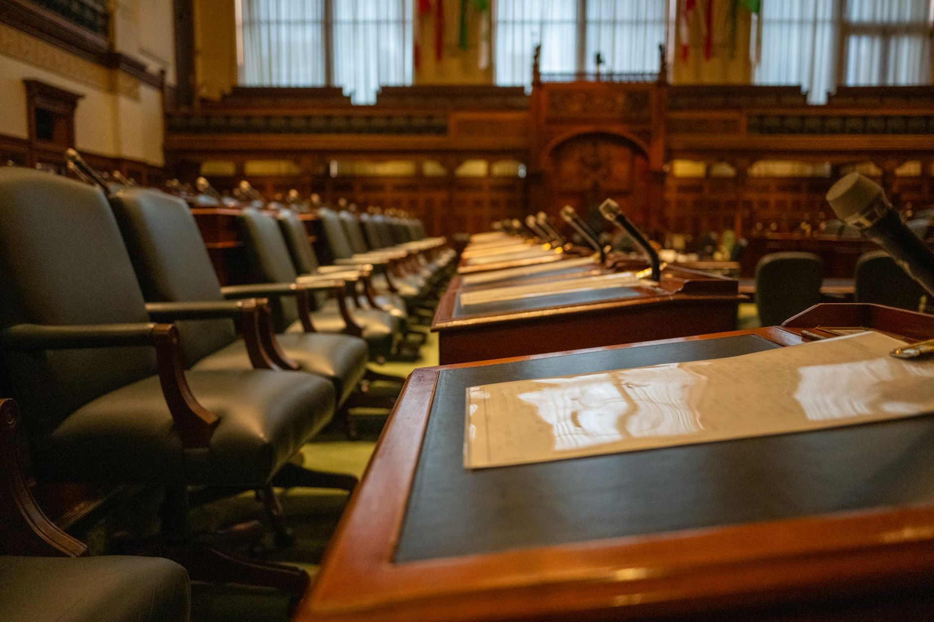 A detailed view of an empty legislative chamber with rows of desks