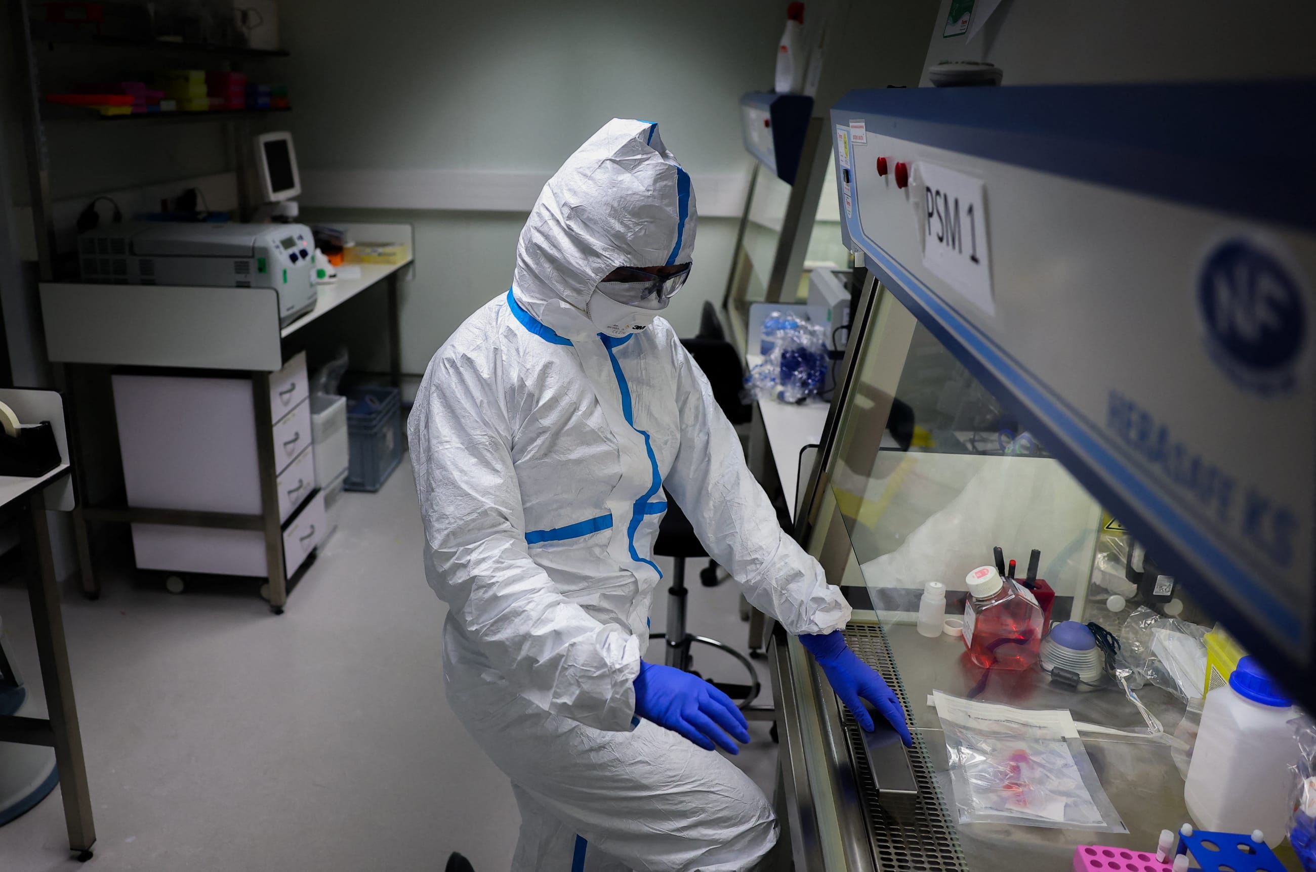 A researcher wearing a protective suit works at the Institut Pasteur, where