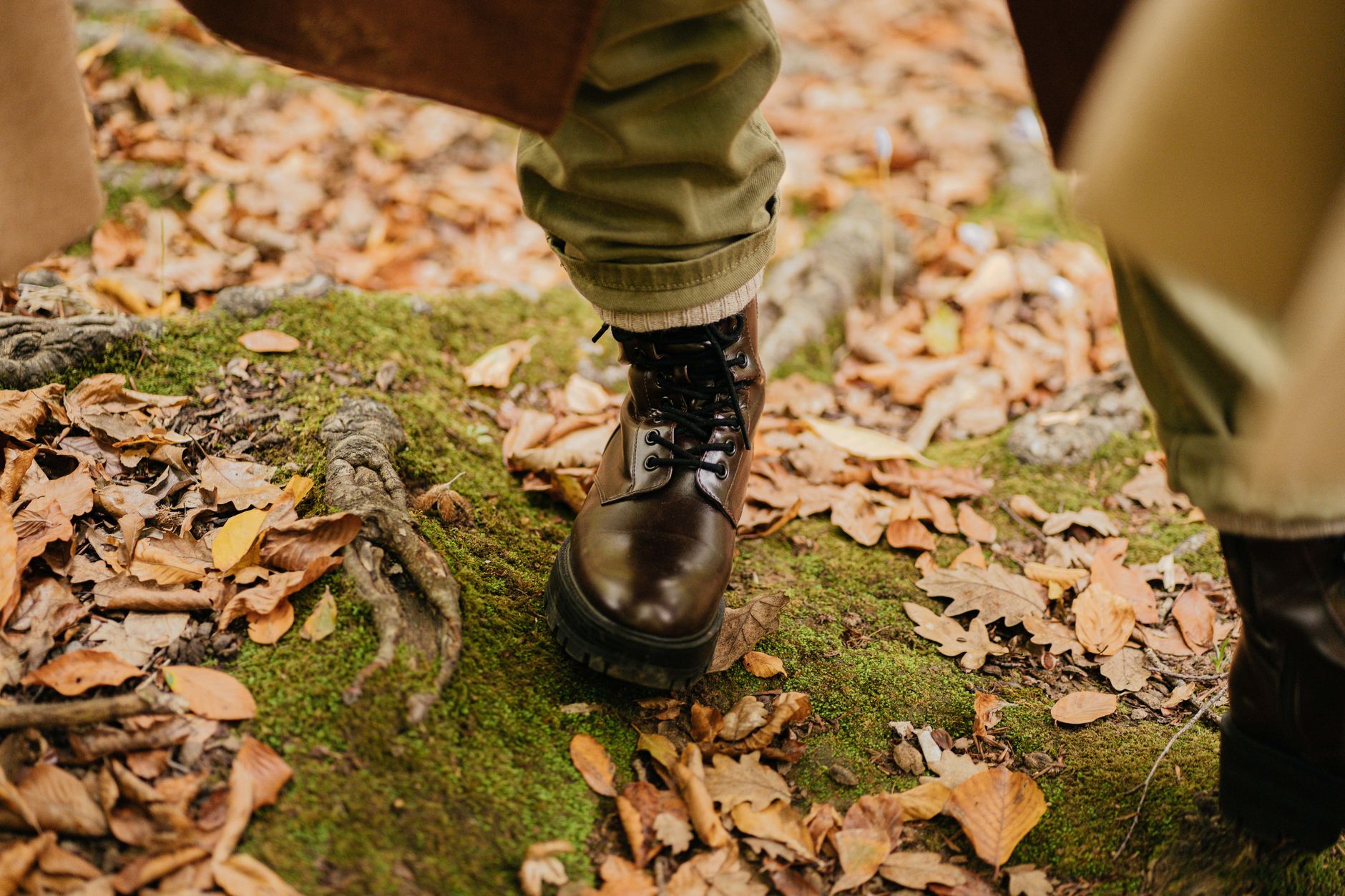 Close-up of a person walking in a forest in leather boots, surrounded
