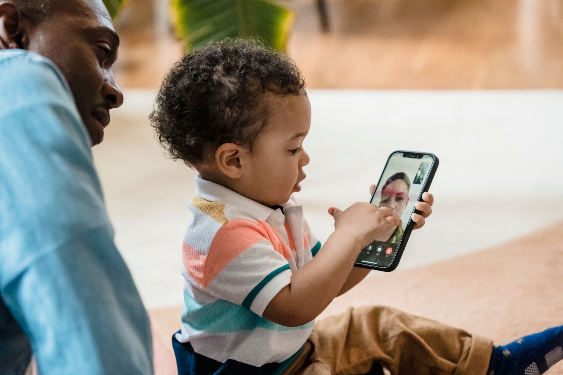 A child using a smartphone for a video call, learning technology skills