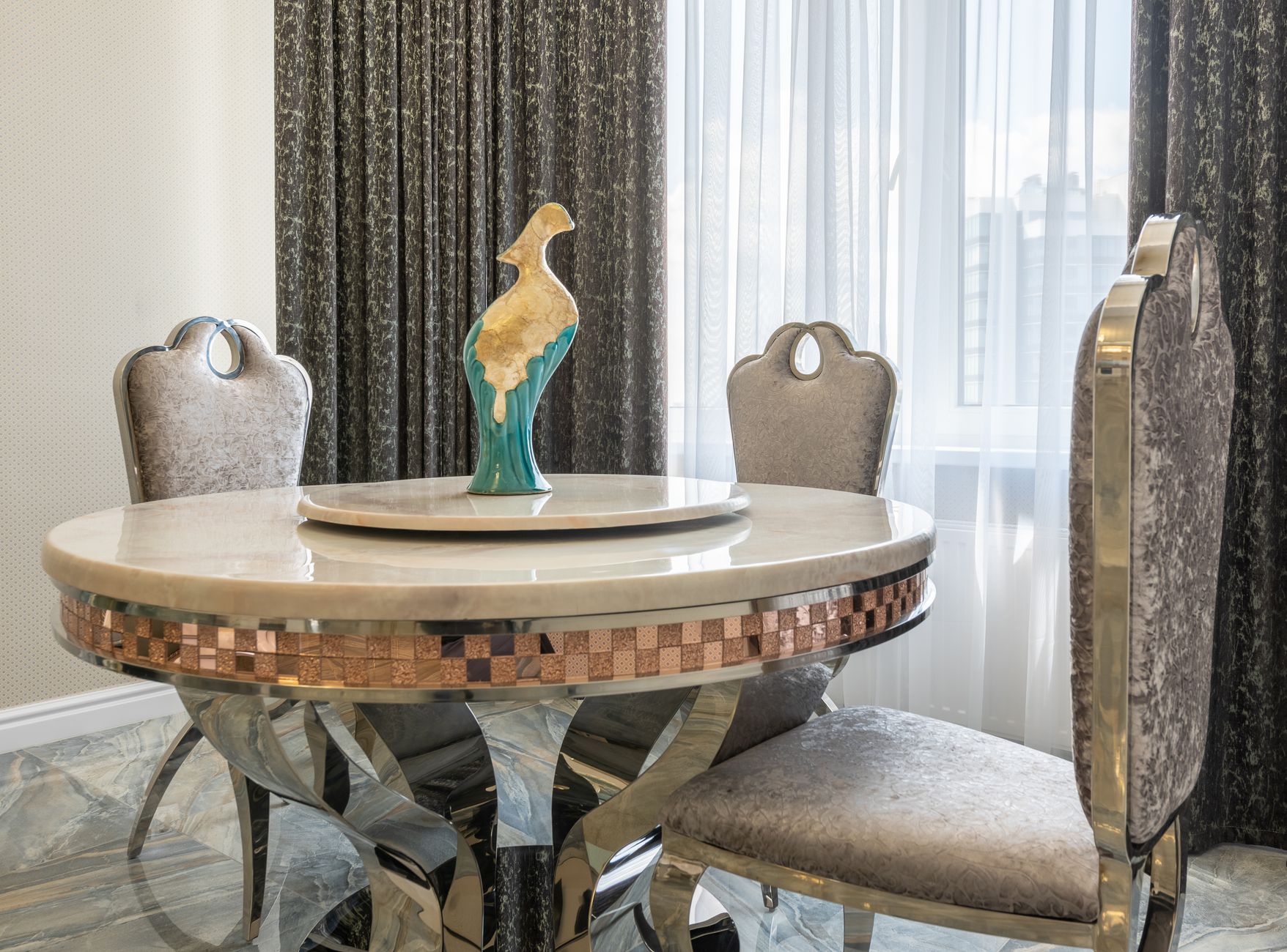 Statuette on round shaped table between classic chairs on marble floor in